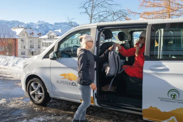 A patient is picked up by the Alpstein Clinic shuttle bus.