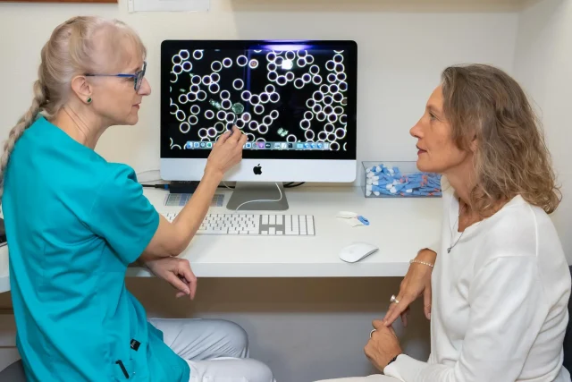Alternative practitioner Maria Dobler-Gisiger shows a patient her dark field microscopy.