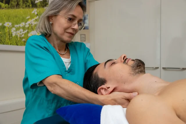 Medical masseuse massages a patient's neck