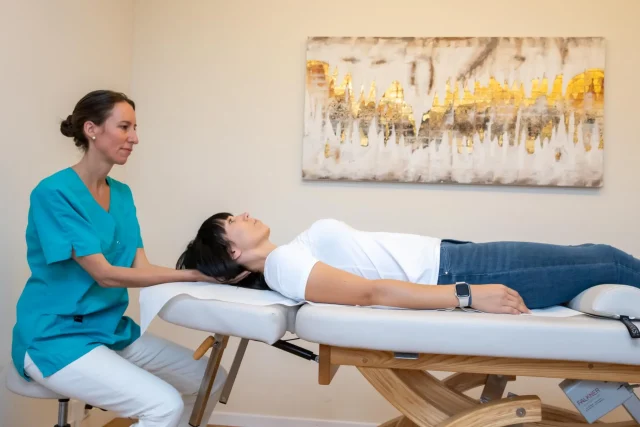 A therapist performs manual therapy on a patient.