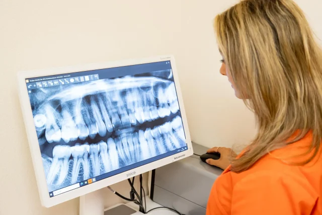 Dental assistant looking at an X-ray image of a jaw